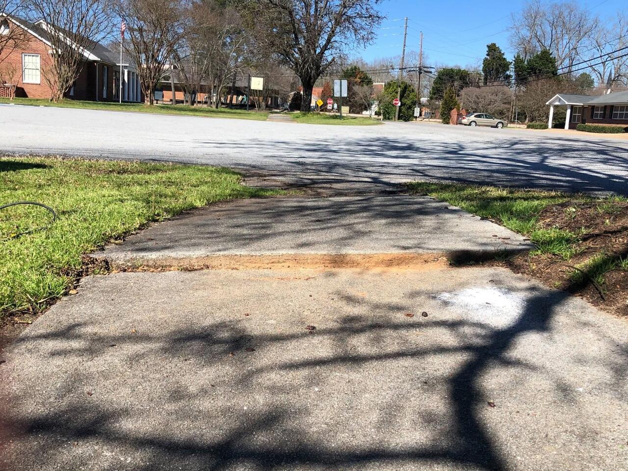 Sunken slab along brick wall lifted level