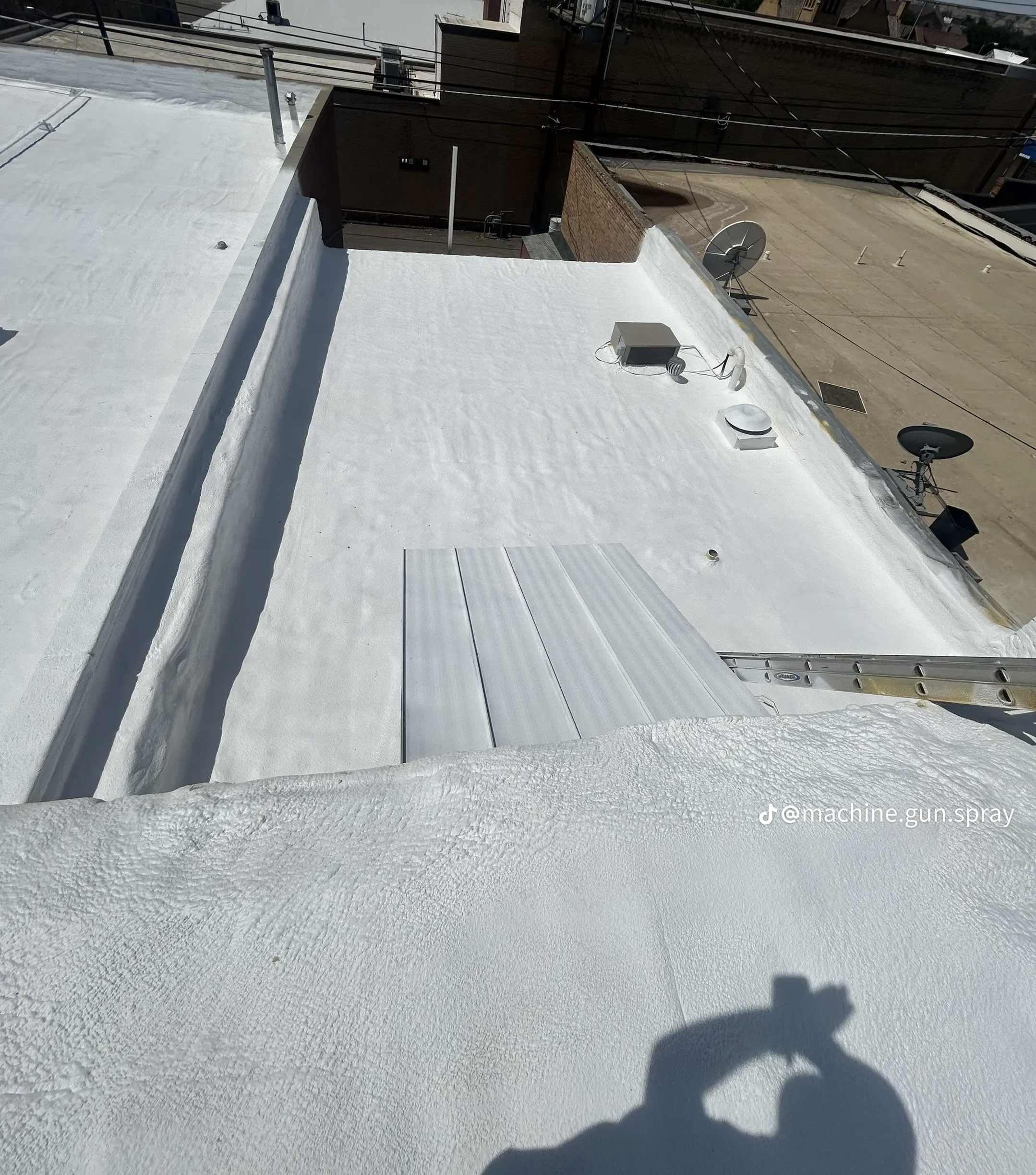 White SPF foam roof coating on a commercial building